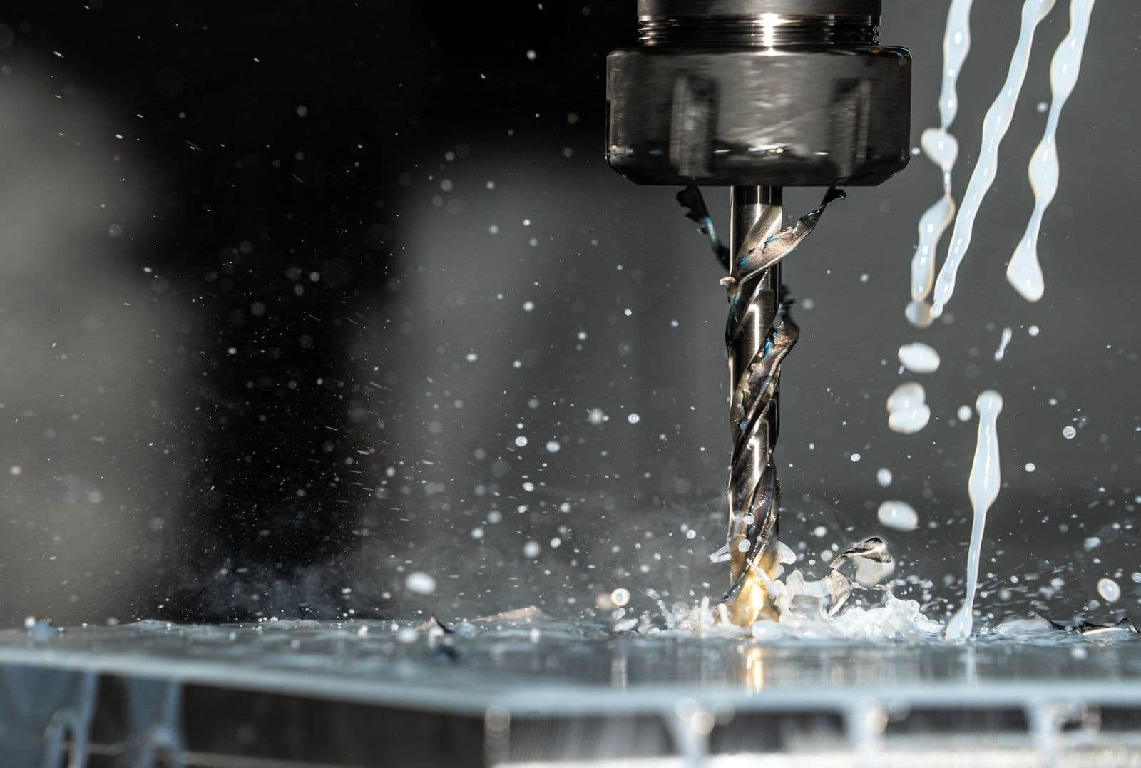 CNC milling center cutting metal with coolant spray — precision contract machining