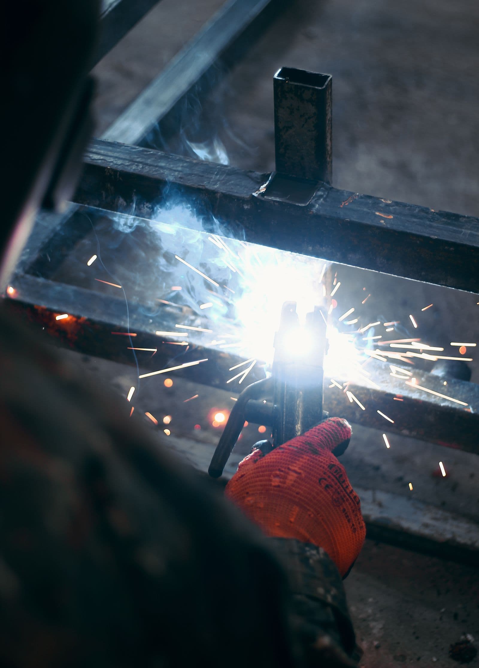 MIG/MAG welding of a steel assembly with sparks — structural fabrication